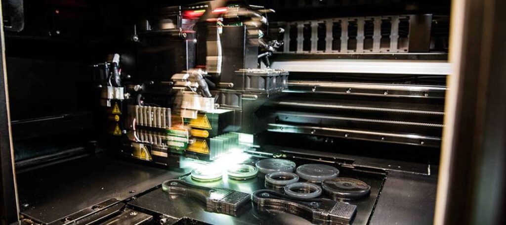 Industrial 3D printer creating plastic parts.